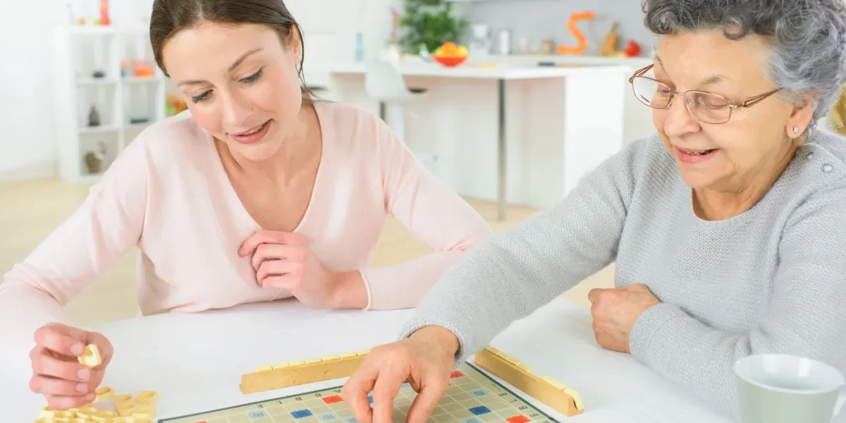 Senior woman playing board game with relative Senior woman playing board game with relative